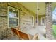 View of brick porch with porch swing, windows and two exterior doors at 5032 Eagles Crest Ln, Gastonia, NC 28056