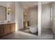 Modern bathroom featuring wood cabinets, soaker tub, and a separate glassed-in shower at 5039 Eliza Long Wilkie Dr, Huntersville, NC 28078
