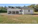 Three-car garage featuring white brick and black trim with a sprawling yard at 5039 Eliza Long Wilkie Dr, Huntersville, NC 28078
