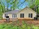 View of the home's exterior featuring a small patio, BBQ grill, and spacious backyard at 6520 White Pine Ln, Charlotte, NC 28262