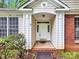 Home's inviting front entrance features a covered porch and decorative door with sidelights at 6520 White Pine Ln, Charlotte, NC 28262
