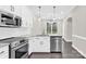 This modern kitchen features sleek stainless steel appliances and a view to the backyard at 6520 White Pine Ln, Charlotte, NC 28262