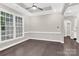 Bright living room boasting neutral paint, dark hardwood floors, ceiling fan, and natural lighting at 6520 White Pine Ln, Charlotte, NC 28262