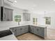 Open kitchen boasts gray cabinets, stainless appliances, white countertops, and seamless access to dining area at 701 Applewood St, Kannapolis, NC 28081
