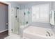 Bright bathroom featuring a glass-enclosed shower, jet tub, and shuttered window at 706 Springwood Dr # 14, Waxhaw, NC 28173