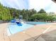 Community pool with a slide and lounge chairs providing a fun and relaxing place for residents at 706 Springwood Dr # 14, Waxhaw, NC 28173