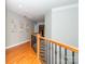 Upstairs hallway with hardwood floors, wrought iron railing, and decorative wall art at 706 Springwood Dr # 14, Waxhaw, NC 28173