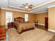 Carpeted main bedroom featuring a trey ceiling, ceiling fan, large rug, and two windows at 706 Springwood Dr # 14, Waxhaw, NC 28173
