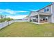 Spacious backyard with large, covered patio, lush lawn, and privacy fence is perfect for entertaining at 7278 Waterwheel St, Concord, NC 28025