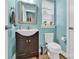 Cozy bathroom with a dark wood vanity, toilet, decorative mirror, and fresh paint at 7278 Waterwheel St, Concord, NC 28025