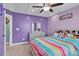 Colorful ' bedroom with a dresser, bed, and purple walls at 7278 Waterwheel St, Concord, NC 28025