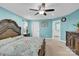 A teal bedroom with an ornate bed, ceiling fan, and adjacent bathroom at 7278 Waterwheel St, Concord, NC 28025