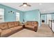 Inviting bonus room with a brown couch, three bright windows and a ceiling fan at 7278 Waterwheel St, Concord, NC 28025