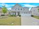 Charming two-story home featuring a well-manicured lawn, flower beds, and an attached two-car garage at 7278 Waterwheel St, Concord, NC 28025