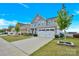 Exterior view of a two-story home, highlighting the driveway, lawn, and landscaping at 7278 Waterwheel St, Concord, NC 28025