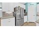 Close-up view of the stainless steel refrigerator, white cabinetry, granite countertops, and tile backsplash at 7278 Waterwheel St, Concord, NC 28025