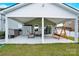 Covered patio features ample seating and a porch swing perfect for entertaining guests at 7278 Waterwheel St, Concord, NC 28025