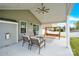 A covered patio is furnished with a seating area and porch swing for relaxing and enjoying the backyard at 7278 Waterwheel St, Concord, NC 28025