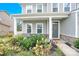 Inviting front porch with stone accents, featuring comfortable seating and a well-maintained garden at 7278 Waterwheel St, Concord, NC 28025