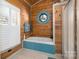 Bright bathroom features a tub with a blue accent and unique porthole window at 8172 Summit Ridge Dr, Catawba, NC 28609