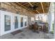 Covered outdoor patio with stone accents, ceiling fan, and comfortable dining area at 8172 Summit Ridge Dr, Catawba, NC 28609
