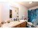 A bright bathroom featuring double vanity sinks, a toilet, and a shower with a blue shower curtain at 87 Green Meadows Dr, Taylorsville, NC 28681