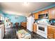 Spacious kitchen featuring wood cabinets, black flooring, white appliances and an eat-in kitchen at 87 Green Meadows Dr, Taylorsville, NC 28681