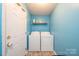 Functional laundry room with appliances and shelf, offering convenience and practicality at 87 Green Meadows Dr, Taylorsville, NC 28681