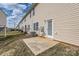 Backyard showcasing a concrete patio, grassy area, and exterior of the building, highlighting outdoor living potential at 9035 Bradstreet Commons Way, Charlotte, NC 28215