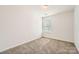 A well-lit bedroom with plush carpet, a window, and a minimalist design creating a serene atmosphere at 9035 Bradstreet Commons Way, Charlotte, NC 28215