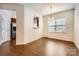 Bright dining area with wood floors, chandelier, and natural light from the window with modern blinds at 9035 Bradstreet Commons Way, Charlotte, NC 28215