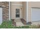 Close up of townhome front door with sidelight, house number, landscaping, and siding details at 9035 Bradstreet Commons Way, Charlotte, NC 28215