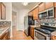 Well-lit kitchen featuring stainless steel appliances, wood cabinets, granite countertops, and mosaic tile backsplash at 9035 Bradstreet Commons Way, Charlotte, NC 28215