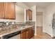 Kitchen area featuring stainless steel sink, granite countertops, wood cabinets, and mosaic tile backsplash at 9035 Bradstreet Commons Way, Charlotte, NC 28215