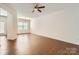 Living room featuring hardwood floors, ceiling fan, a large window and base molding at 9035 Bradstreet Commons Way, Charlotte, NC 28215