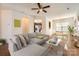 Open concept living room with wood flooring, ceiling fan, and sight lines to the dining area and kitchen at 9035 Bradstreet Commons Way, Charlotte, NC 28215