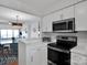 Bright kitchen features stainless steel appliances and a view through to the dining room and fireplace at 9808 Emerald Point Dr # 10, Charlotte, NC 28278