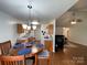 Eat-in kitchen area with a round wooden dining table and seating, adjacent to the kitchen and living room at 1015 Raywood Ct, Matthews, NC 28104