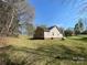 Side view of a cozy home with a backyard, trees and grass at 1015 Raywood Ct, Matthews, NC 28104
