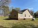 Side view of a cozy home with a backyard, trees and grass at 1015 Raywood Ct, Matthews, NC 28104