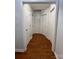 Bright hallway featuring multiple closet doors and gleaming hardwood floors at 1015 Raywood Ct, Matthews, NC 28104