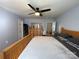 Main bedroom featuring hardwood floors, a ceiling fan, neutral walls, and a large queen-sized bed at 1015 Raywood Ct, Matthews, NC 28104