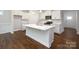 Bright kitchen featuring white cabinets, a large island, and stainless steel appliances at 115 S Shayna Rd, Troutman, NC 28166