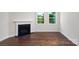 Cozy living room featuring a fireplace, dark wood floors, and natural light from large windows at 115 S Shayna Rd, Troutman, NC 28166