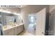 Bright bathroom featuring double vanity, a mirror, and an open doorway to the bedroom at 122 N Shayna Rd, Troutman, NC 28166