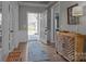Welcoming foyer with hardwood floors, stylish cabinet, and an open door to the exterior view of well-maintained landscaping at 12709 Messenger Row, Huntersville, NC 28078