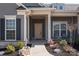 Inviting front entrance with elegant door, decorative sidelights, and manicured landscaping featuring river rock and seasonal flowers at 12709 Messenger Row, Huntersville, NC 28078