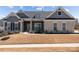Attractive single-Gathering home featuring a combination of stone and gray siding, complemented by manicured landscaping and dark shutters at 12709 Messenger Row, Huntersville, NC 28078