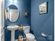 Stylishly decorated half bathroom features pedestal sink, toilet, and tasteful wall art at 12709 Messenger Row, Huntersville, NC 28078