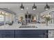 A kitchen island with stainless steel sink and faucet has an open view to a living room with a fireplace at 12709 Messenger Row, Huntersville, NC 28078